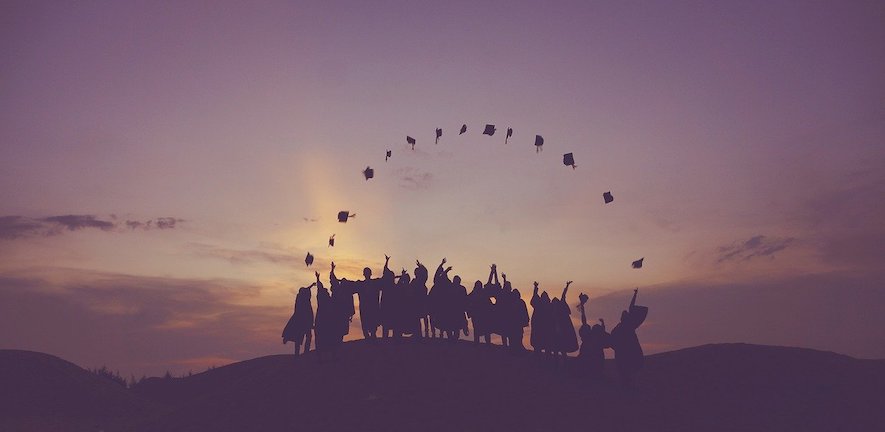People throwing graduation hats in front of a sunset, by Pexels from Pixabay 